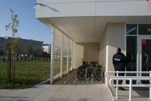 Miejsce parkowania rowerów, w tle widać policjanta oglądającego miejsce zdarzenia
