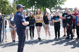 policjant rozmawia z grupą młodzieży